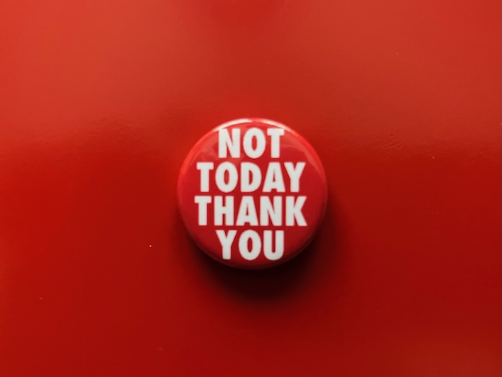 Close up of a red button badge that says 'Not today thank you' in white text
